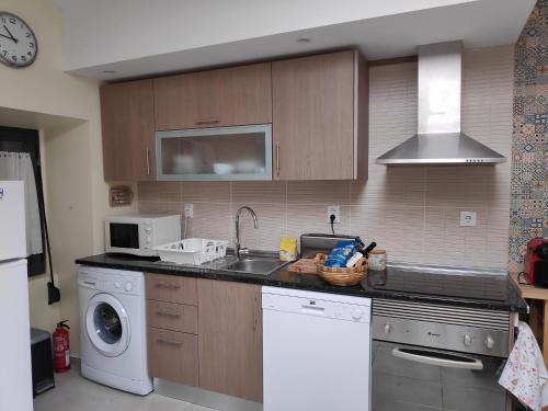 a kitchen with a sink and a washing machine at The Sunny Cottage in Faro