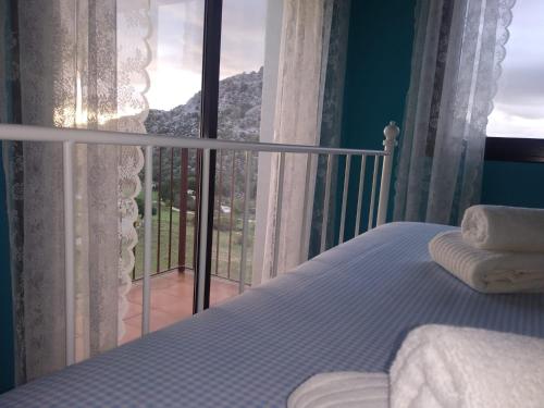 a bedroom with a bed and a view of a balcony at La Atalaya in Benaocaz