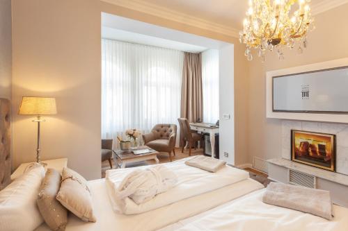 a living room with a white couch and a fireplace at Hotel Vier Jahreszeiten Binz in Binz