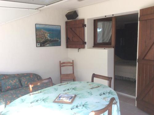 a room with a table and chairs and a couch at GITE AGUR in Villefranque