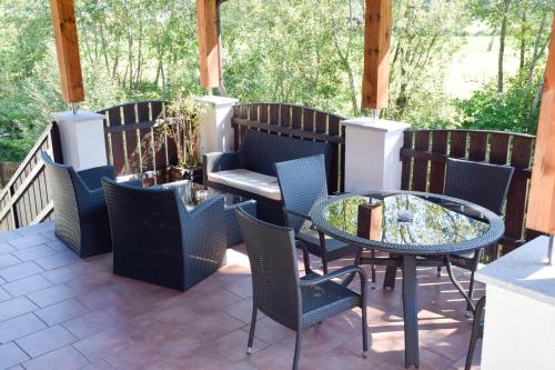 eine Terrasse mit einem Tisch und Stühlen auf einer Terrasse in der Unterkunft Tischlmühle Appartements & mehr in Gröbming