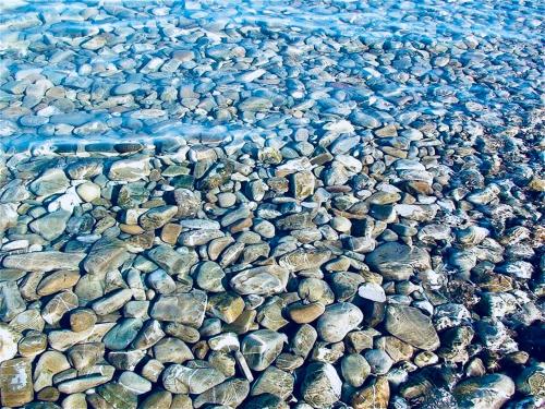a bunch of rocks on a beach with water at B&B Rosa dei Venti in Roseto Capo Spulico