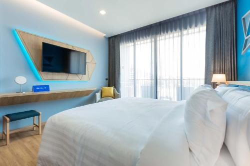 a hotel room with a bed and a tv at BlueSotel SMART Krabi Aonang Beach - Adults only in Ao Nang Beach