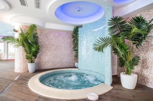 ein Whirlpool in einem Zimmer mit Palmen in der Unterkunft Castelnor in Păltiniş