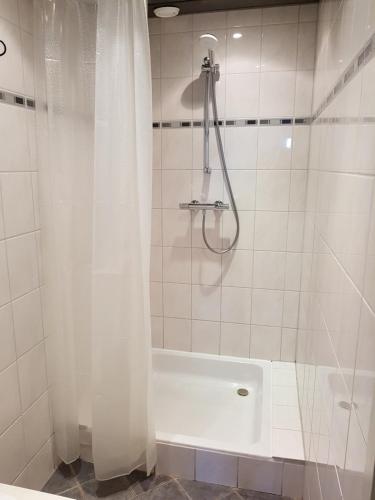 La salle de bains est pourvue d'une douche avec un rideau de douche blanc. dans l'établissement Hotel Kuiperduin, à Hoek van Holland