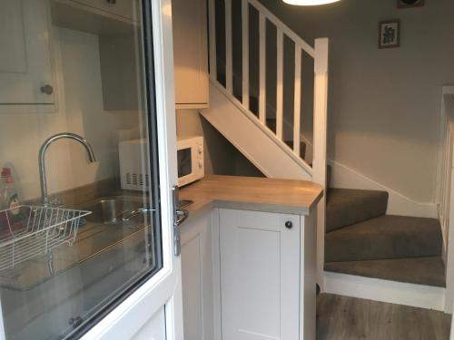 a small kitchen with a sink and a staircase at Self-Contained Accommodation for 2 in Keswick