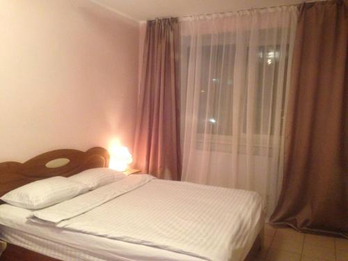a bedroom with a white bed with a window at Apartment Mlynivs'ka 29 A in Rivne
