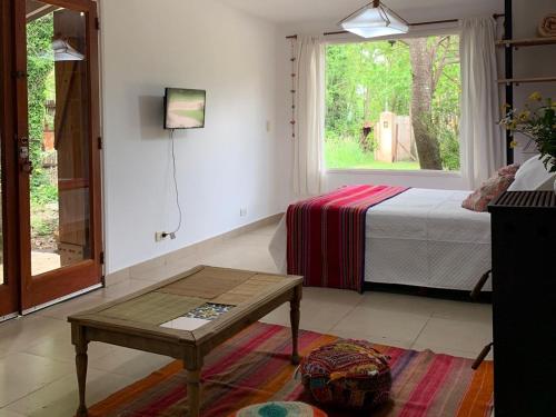 a bedroom with a bed and a table and a window at La casa de Caro in Mar de Cobo