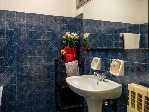 a bathroom with a sink and a blue tiled wall at Camera Rustica in Valpolicella con parcheggio in Pescantina
