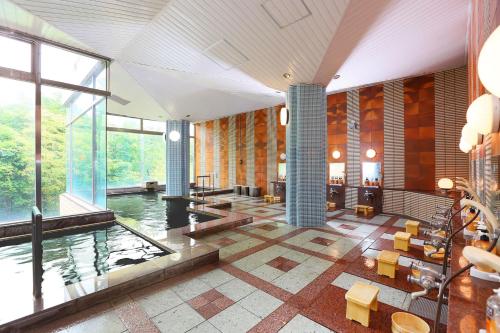 Hotel Floracion Nasu في ناسو: غرفة كبيرة مع مسبح في مبنى