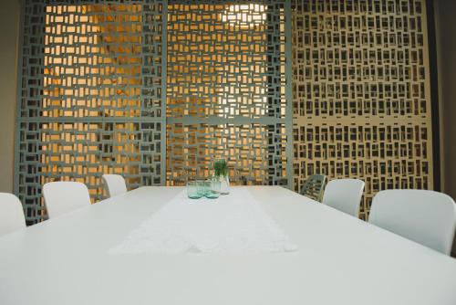 a white table in a room with white chairs at The Rambam Residence - By Localz Group in Tel Aviv