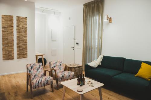 a living room with a green couch and chairs at The Rambam Residence - By Localz Group in Tel Aviv