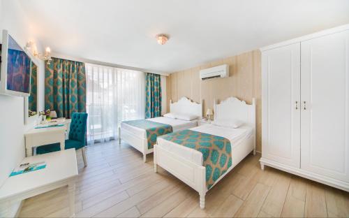 Pokój hotelowy z 2 łóżkami i biurkiem w obiekcie Kleopatra Atlas Hotel - Adults Only w mieście Alanya