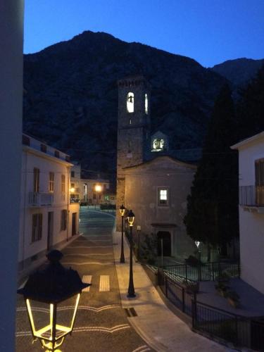a building with a clock tower with a mountain in the background at Da Oreste Affittacamere in Fara San Martino