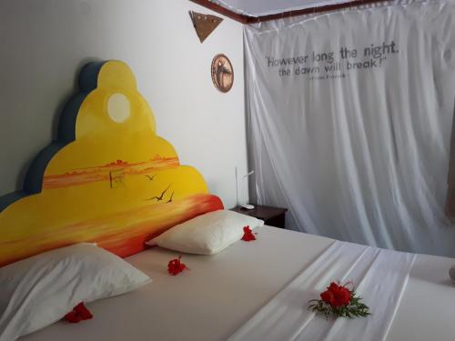 a bedroom with a bed with a large yellow headboard at Mustapha' s Place in Bwejuu