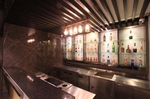 a kitchen with a lot of bottles of alcohol at Pratunam Atrium Hotel in Bangkok