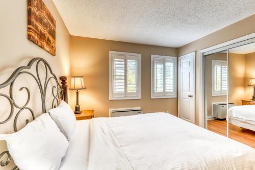 a bedroom with a white bed and windows at Condo 305 at North Creek Resort in Blue Mountains