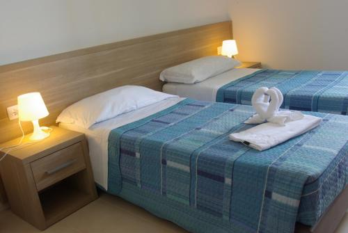 um quarto de hotel com duas camas com toalhas e duas lâmpadas em San Luigi - Residenza Gemelli em Roma