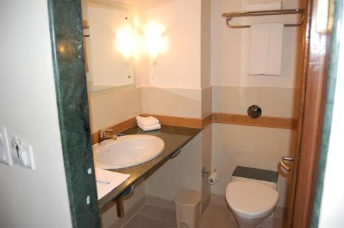 ein Bad mit einem Waschbecken und einem WC in der Unterkunft Martins Comfort in Betalbatim