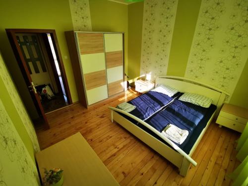 a bedroom with a bed with blue sheets and a mirror at Serdika station, bright and cozy apartment in Sofia