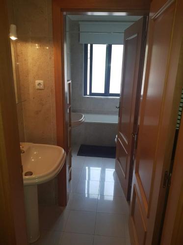 a bathroom with a sink and a toilet and a tub at Appartement Quinta de Palames Sesimbra in Sesimbra