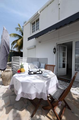 a table and chairs on a patio in front of a house at Locastudio - Pomme Kanel in Sainte-Anne