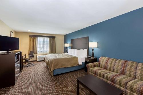 a hotel room with a bed and a couch at AmericInn by Wyndham Jefferson in Jefferson
