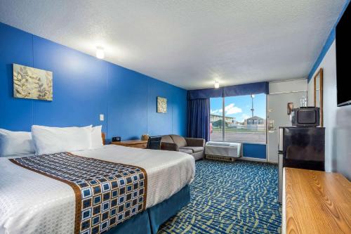 ノース・プラットにあるHospitality Innの大きなベッドとソファが備わるホテルルームです。