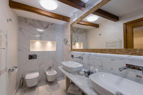 a bathroom with a sink and two toilets at Heritage Hotel San Rocco in Brtonigla