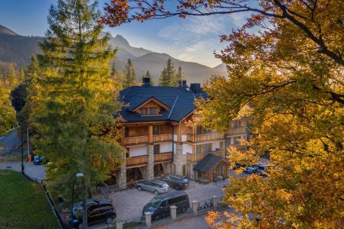 a large house with cars parked in front of it at Hotel Foluszowy Potok in Zakopane