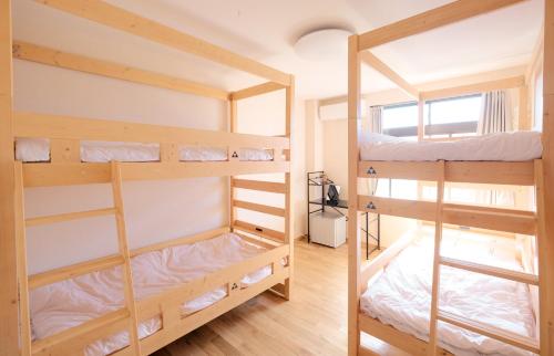 鳥取市にある鳥取ゲストハウス ミライエBASEの窓付きの客室で、二段ベッド2台が備わります。