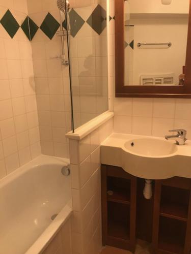 une salle de bain avec un lavabo, une baignoire et un miroir dans l'établissement Studio 4 personnes Villa Maldagora Ciboure (St jean de Luz/Soccoa), à Ciboure