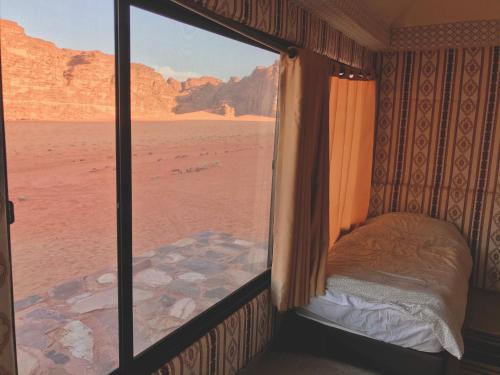 una camera da letto con finestra affacciata sul deserto di wadi rum Mater camp a Wadi Rum