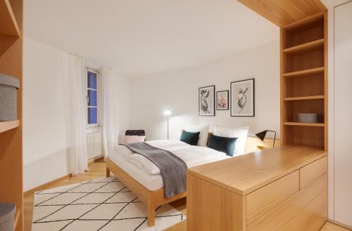 ボルツァーノにあるFranciscus Apartmentsのベッドと木製の机のある寝室