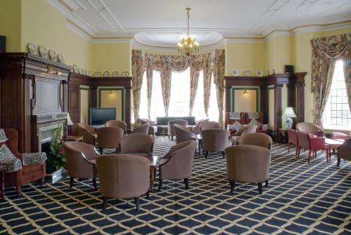 a room with chairs and a waiting room with a fireplace at Prince Of Wales Hotel in Southport
