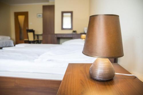 a brown lamp sitting on a table next to a bed at Willa Orfa in Nadole