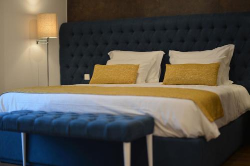 a large bed with a blue headboard and two pillows at Casa das Carpas in Vizela