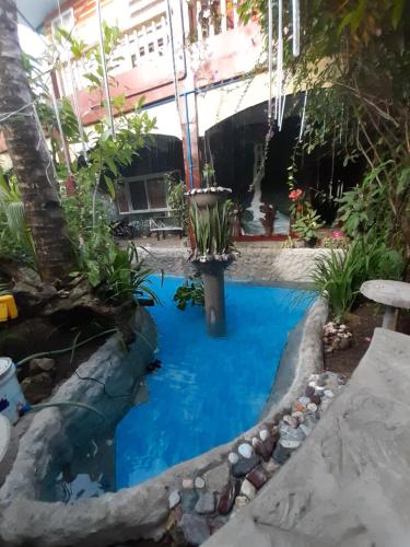 a pool in the middle of a garden at Toni Arts Villa in Nabas