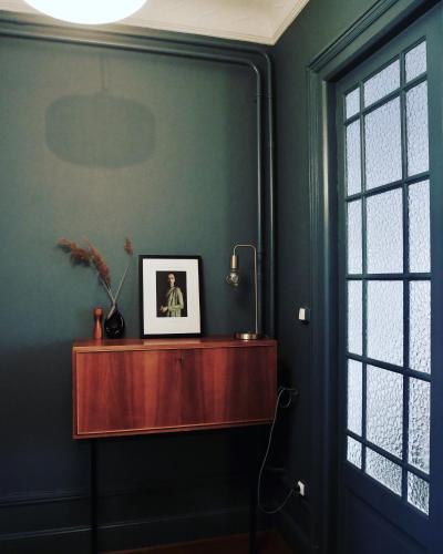 a room with green walls and a wooden table at L’Appartement des Glières Annecy centre in Annecy