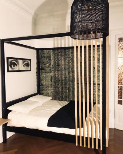 ein Schlafzimmer mit einem schwarzen Etagenbett mit weißer Bettwäsche in der Unterkunft L’Appartement des Glières Annecy centre in Annecy