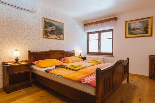 a bedroom with a large wooden bed with yellow pillows at Apartment Ledrar in Bled