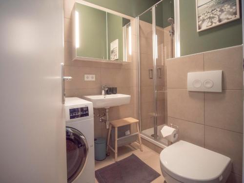 a small bathroom with a toilet and a sink at Green flat by GrazRentals with garden view & parking included in Graz