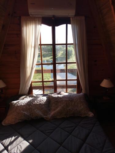 a bedroom with a bed in front of a window at Cabaña Abuelo Ernesto 2 in Colón