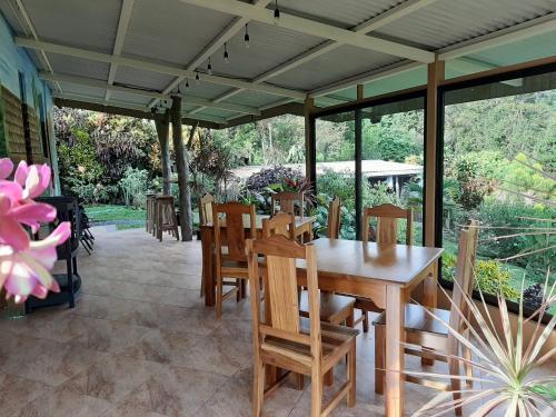 a patio with a wooden table and chairs at Marita's Bed and Breakfast in Nuevo Arenal