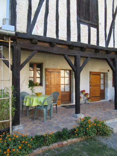 un patio avec une table et des chaises devant un bâtiment dans l'établissement Barbonvielle Astaffort, à Astaffort