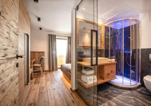 a bathroom with a glass shower and a sink at Hotel Alpenhof in Grossarl