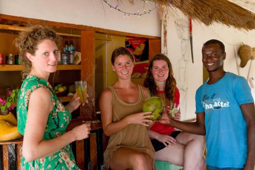 a group of people standing in a kitchen holding drinks at Tamba Kuruba Eco-lodge in Folonko