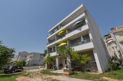 an apartment building with a car parked in front of it at Emilia Lofts in Tučepi
