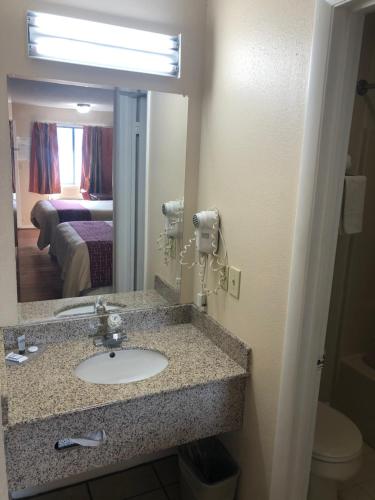Madisonville的住宿－Motor Inns Of America，一间位于酒店客房内的带水槽和镜子的浴室