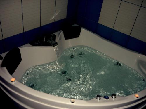 wanna z zieloną wodą w łazience w obiekcie Alkyonis Hotel & Spa w mieście Kato Loutraki